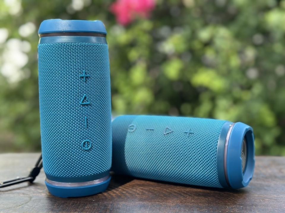 A pair of blue Bluetooth speakers on a table.