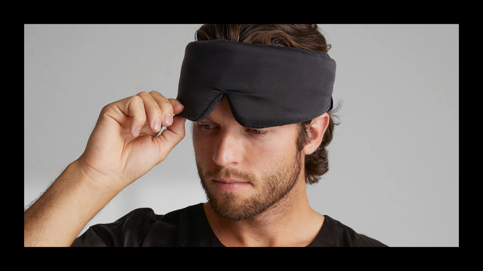 A man wearing a Lunya Sleep Mask