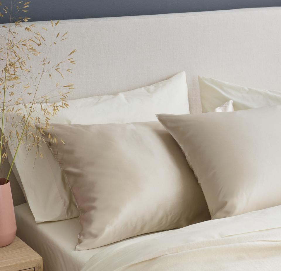 Lifestyle shot of a bed with two Quince Mulberry Silk Pillowcases in the Champagne color.