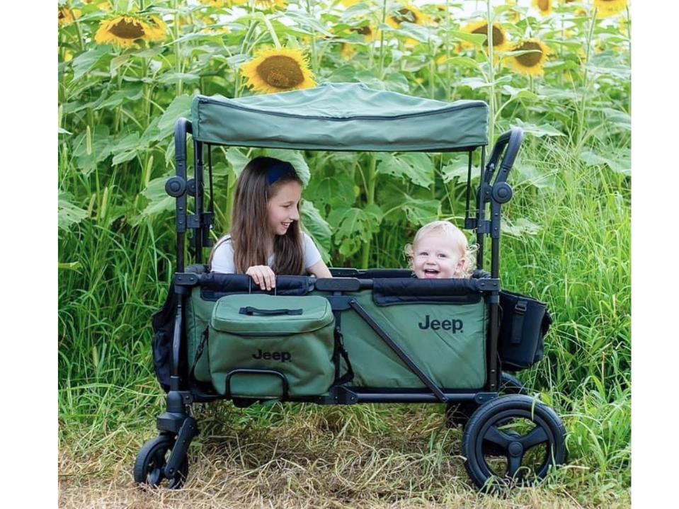 photo of Jeep Deluxe Wrangler Stroller Wagon with 1 kid 1 baby on sunflower field