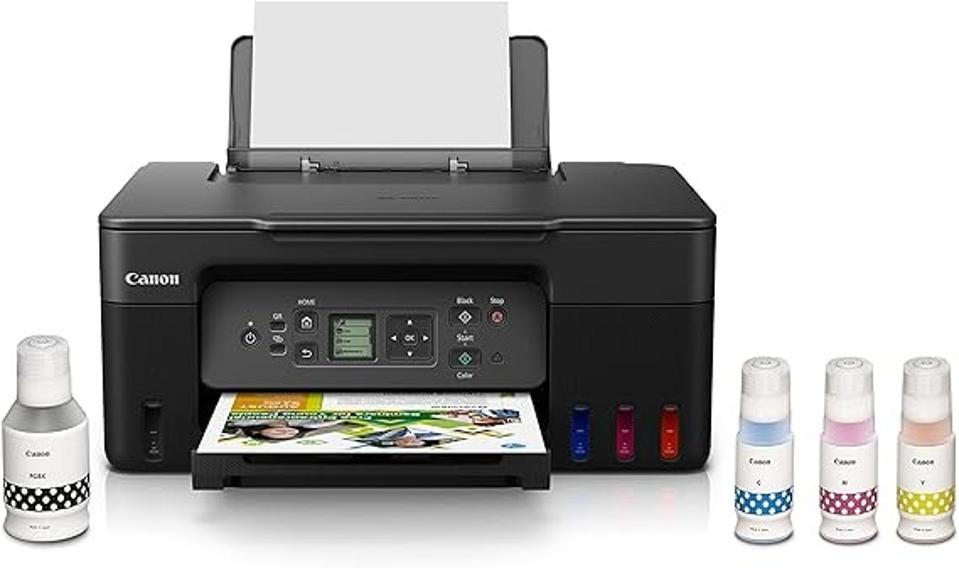 The Canon MegaTank G3270 next to four bottles of ink on a white background.