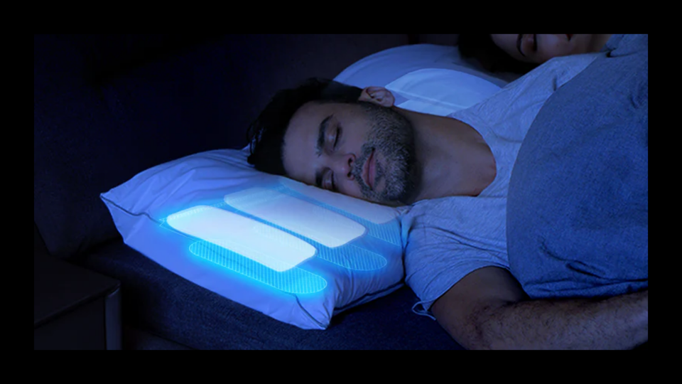 A man sleeping on the Nitetronic Z6 Anti-Snore Pillow with the interior lit up