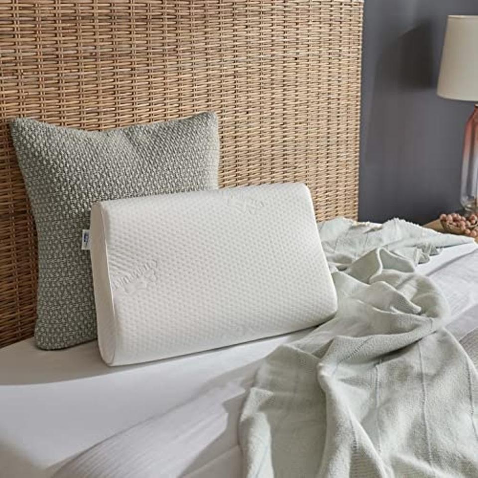 Tempur-Pedic TEMPUR-Ergo Neck Pillow against headboard with throw pillow and sheets.