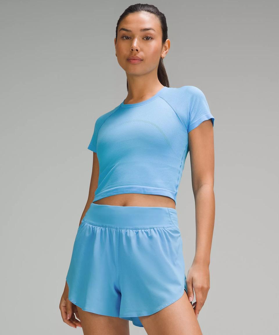 Woman wearing a light Blue Swiftly Tech Cropped Short-Sleeve Shirt.