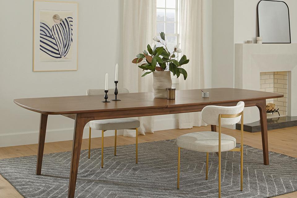 The Plumas Walnut Dining Table in a dining room with two white chairs