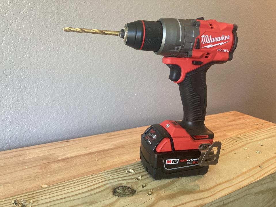 The Milwaukee M18 drill in black and red on top of lumber