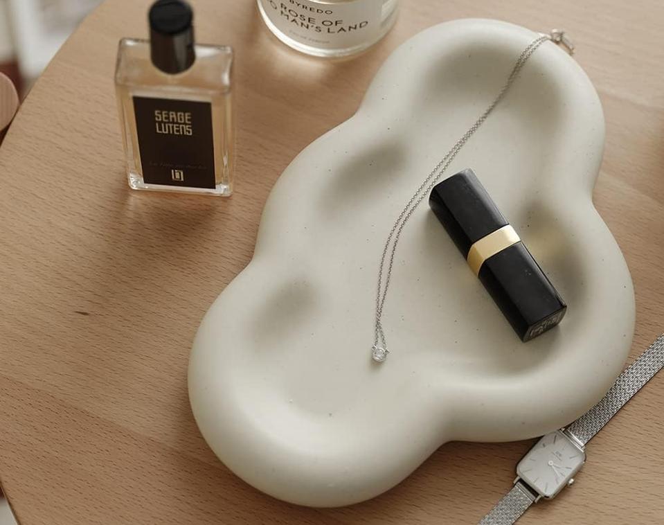 white Wenshuo Cute Cloud Trinket Dish holding lipstick and a necklace on a tabletop. 