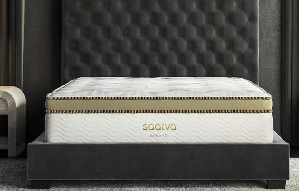 The Saatva HD Mattress on a dark gray bed frame in a bedroom