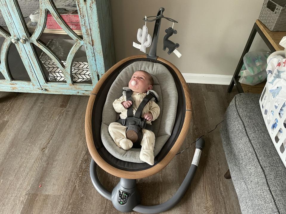 A baby strapped into the Maxi-Cosi Cassia baby swing.