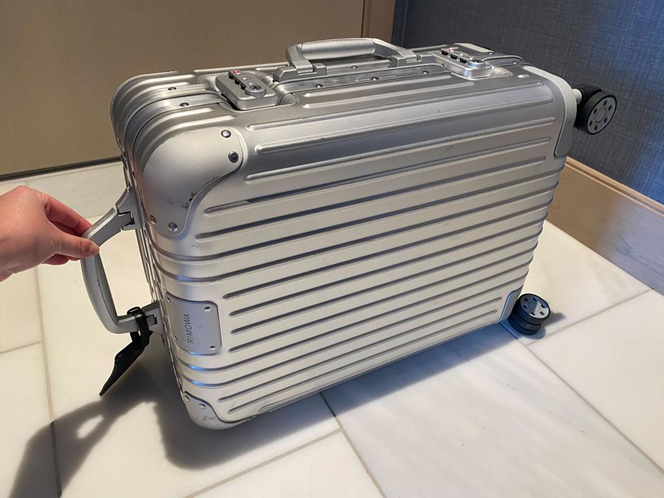 An aluminum suitcase on a tiled floor.