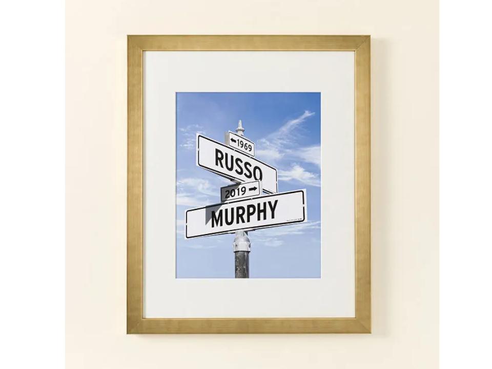 gold-framed photo of street intersection sign black and white with 2019 russo and murphy names on sky background