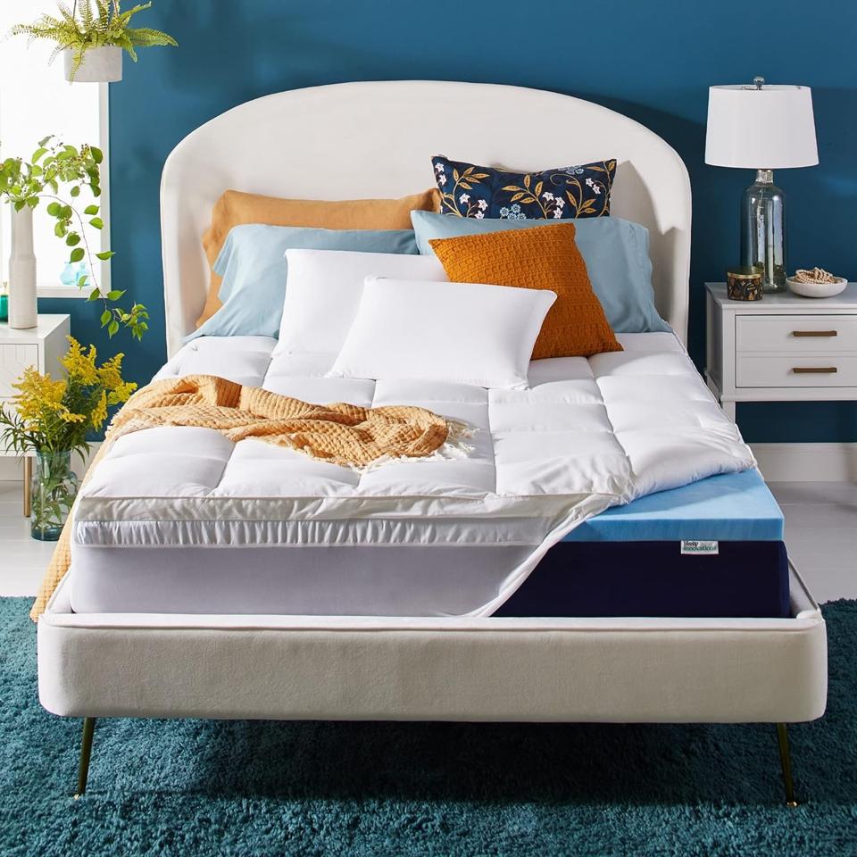 Sleep Innovations Dual Layer 4 Inch Memory Foam Mattress Topper in a blue bedroom