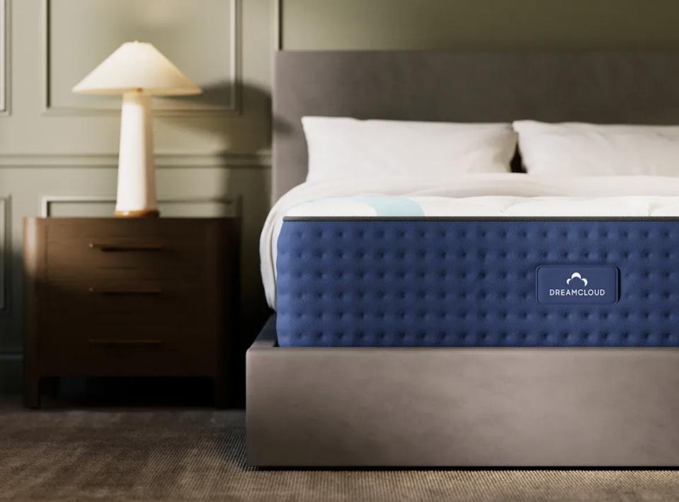 DreamCloud Premier Mattress (Queen) on gray bed frame in a green room with two side tables