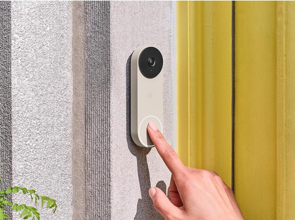 A person pressing the button on the Google Nest Doorbell (Wired, 2nd Gen)