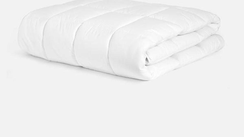 A Brooklinen Down Alternative Topper folded against a white background