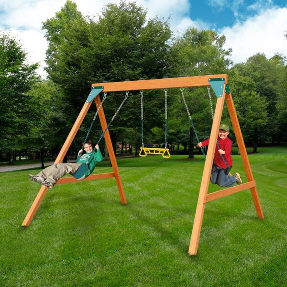 Two kids playing on the Gorilla Playsets Basic Swing Set on a grassy yard