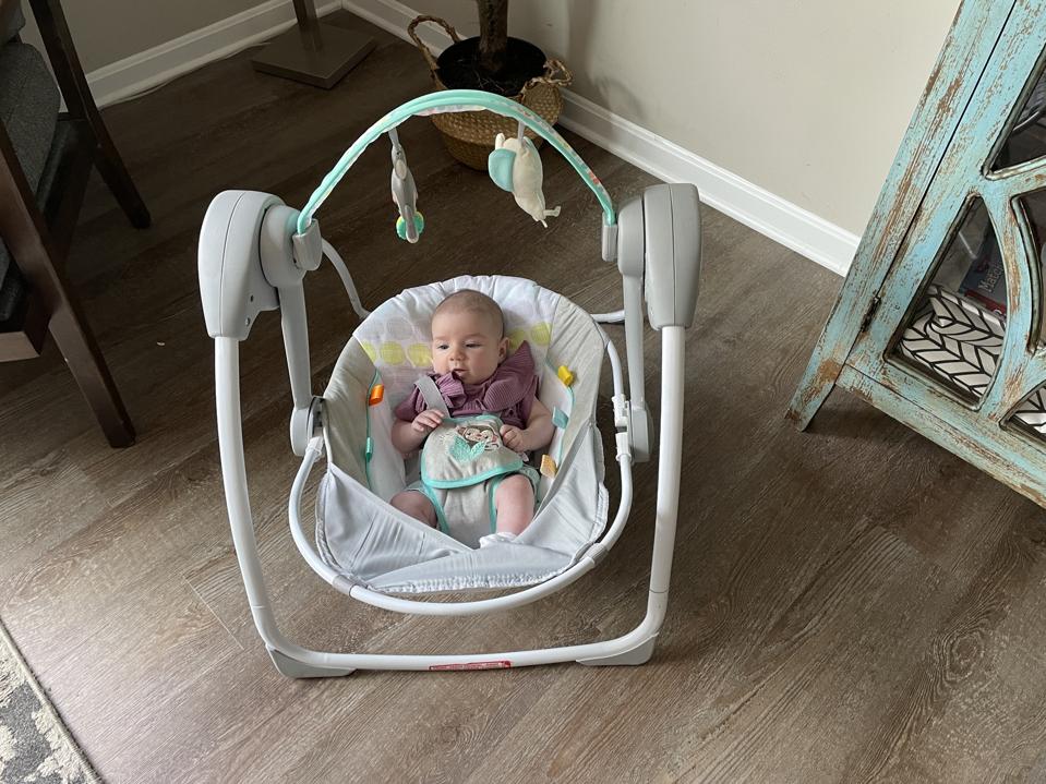 A baby enjoying the Bright Starts Portable baby swing.