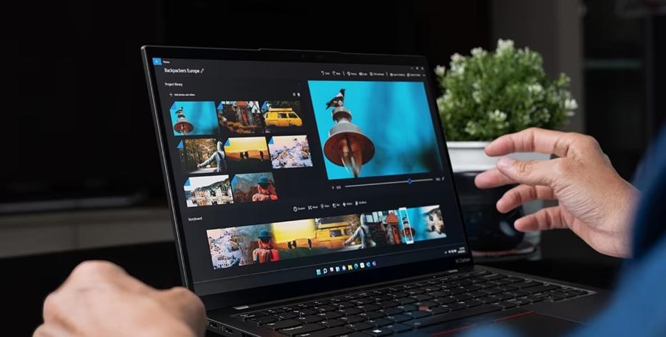 A person seated using the Lenovo ThinkPad Carbon X1 Gen 12 near a potted plant