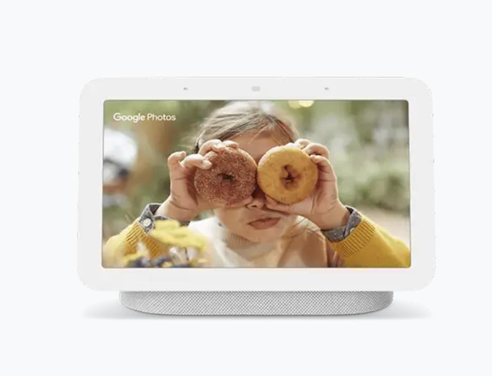 A Google Nest Hub with a photo of a little girl holding doughnuts. 