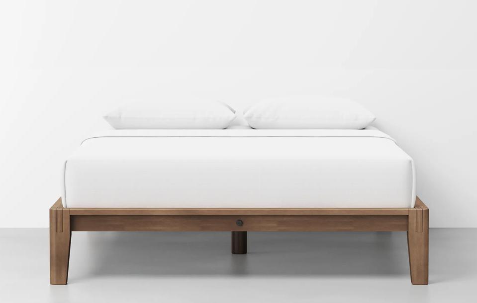 The Thuma Frame with a mattress on top in front of a white wall. 