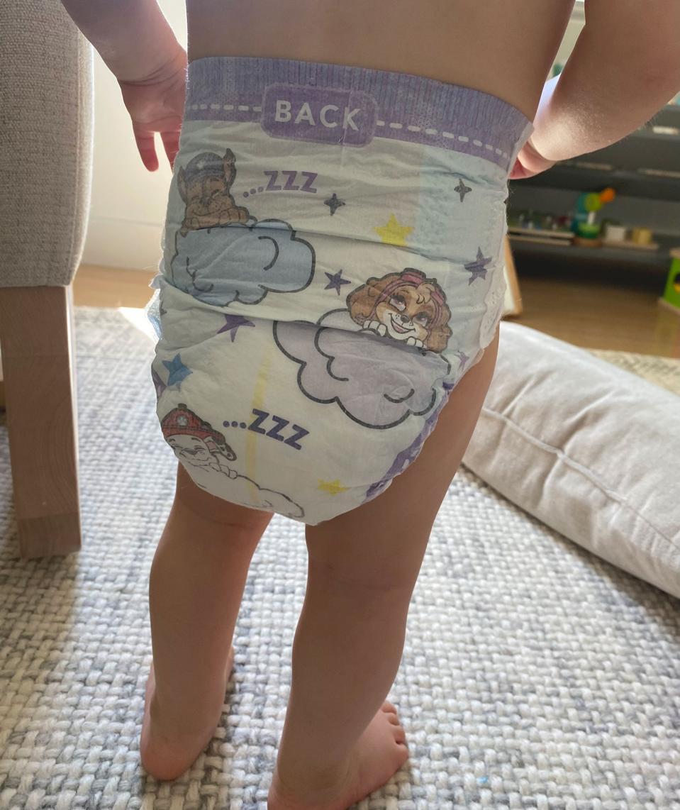 Baby seen from the back wearing Luvs diaper. 