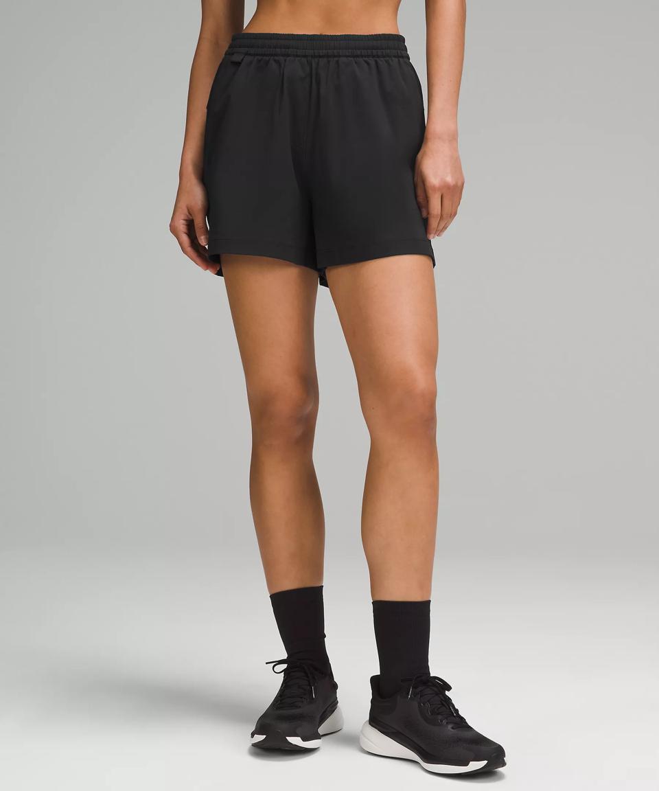 Waist-down shot of woman in Black Lululemon Lightweight High-Rise Hiking Shorts. 