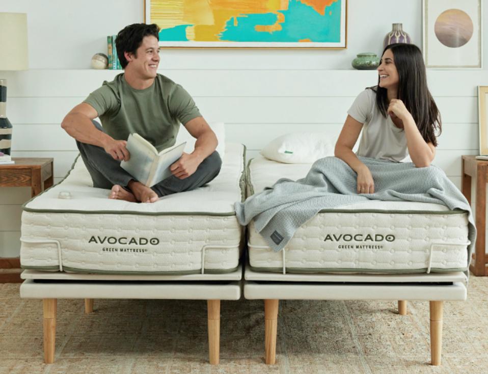 A man lying on one side of the Avocado Eco Pro Adjustable Base in a bedroom