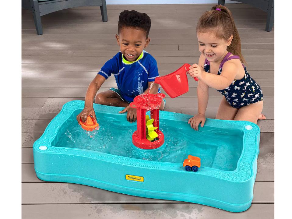 Two kids playing with the Simplay3 Carry & Go Ocean Drive 2-Sided Water Play Table 