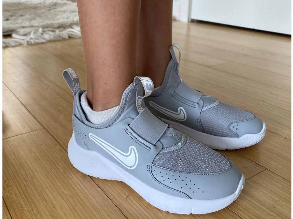 original photo of child's feet wearing gray nike flex runner 3s on wood floor in home