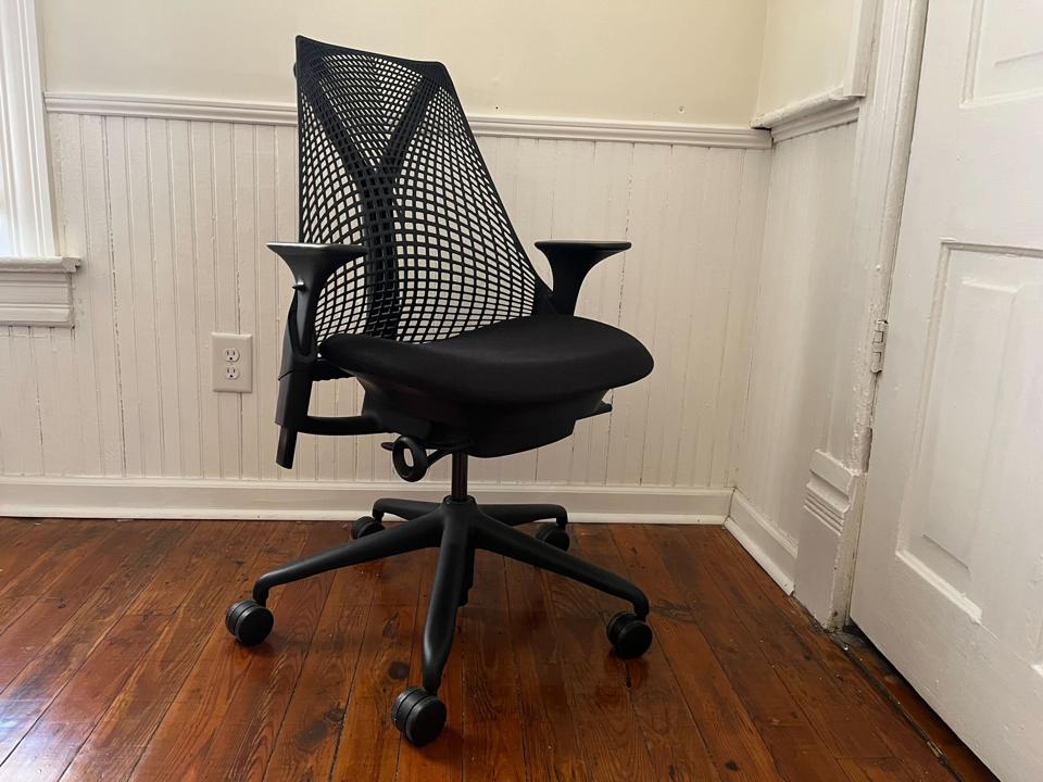 black herman miller sayl chair back support in corner of apartment wood floor white walls