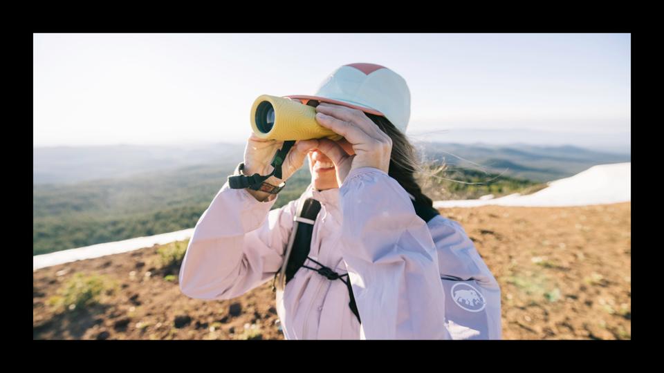 A woman standing on a mountain using the Nocs Zoom Tube