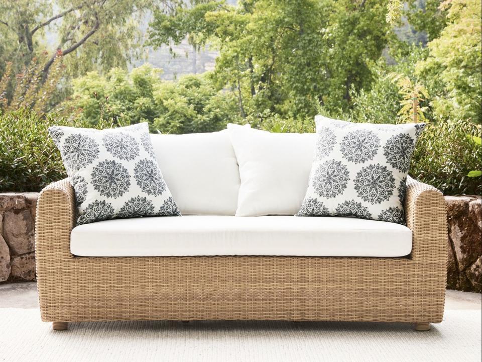 Pottery Barn Gideon Outdoor Sofa on a patio in front of trees