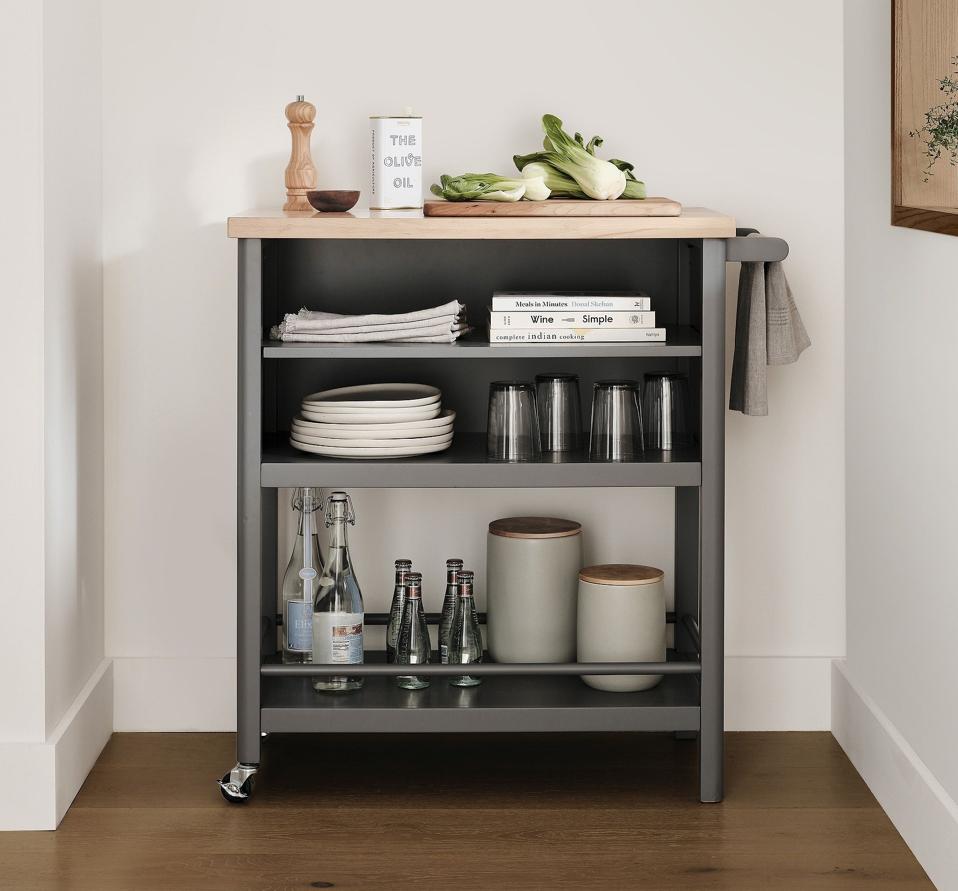 Kaden Rolling Kitchen Cart holding dinnerware and a cutting board