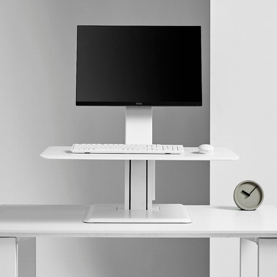 The quickstand eco desk converter with a laptop on it in front of a grey background