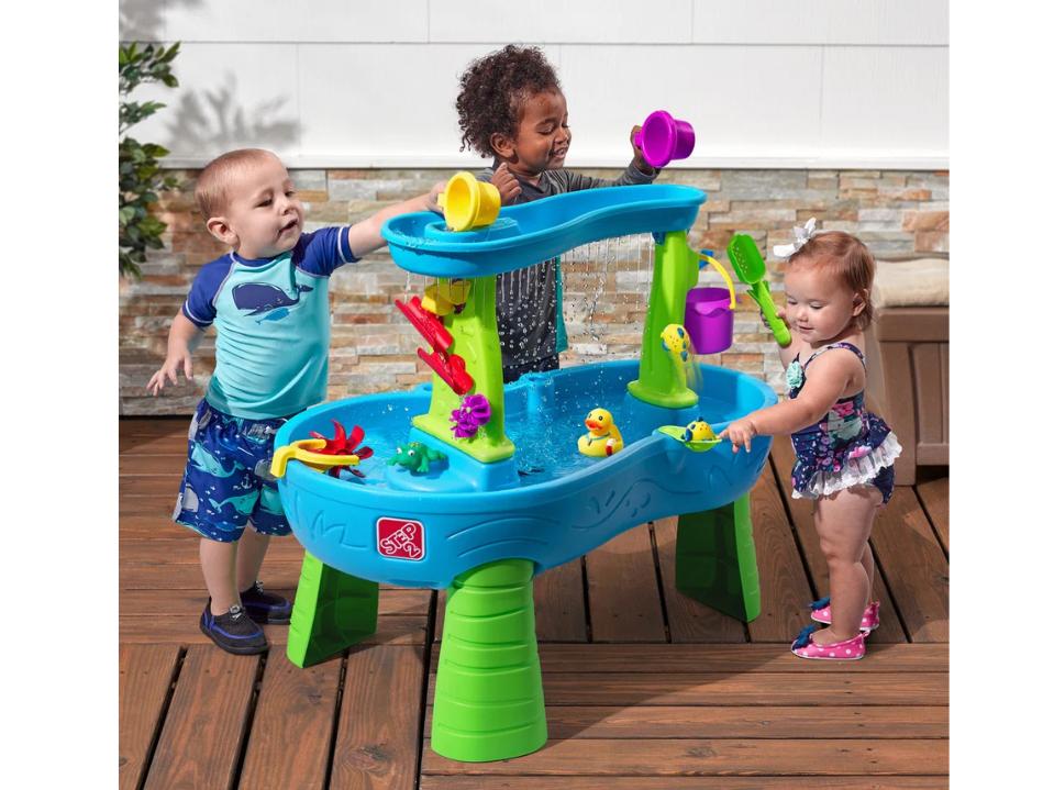 3 toddlers playing at Step2 Rain Showers Splash Pond Water Table outdoors in daytime