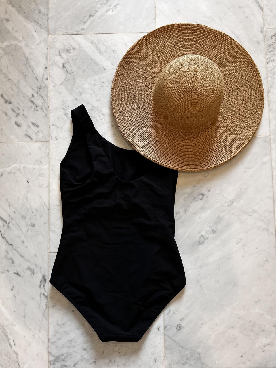 Stylest swimsuit and sunhat on a marble floor