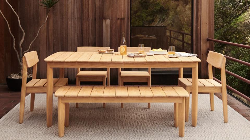 Burrow Dunes Teak Outdoor Dining Table on a rug on a wooden deck