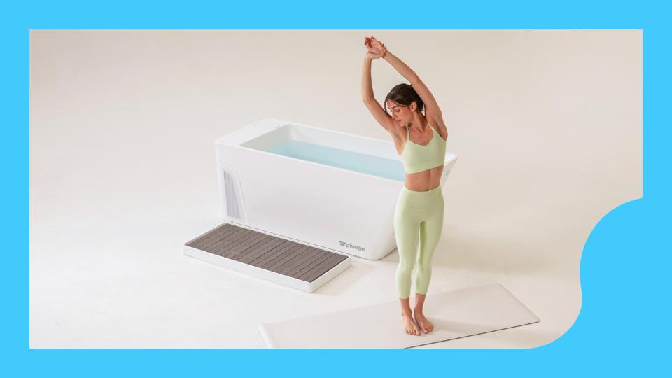 A woman in a light green activewear set stretching in front of a white cold plunge tub