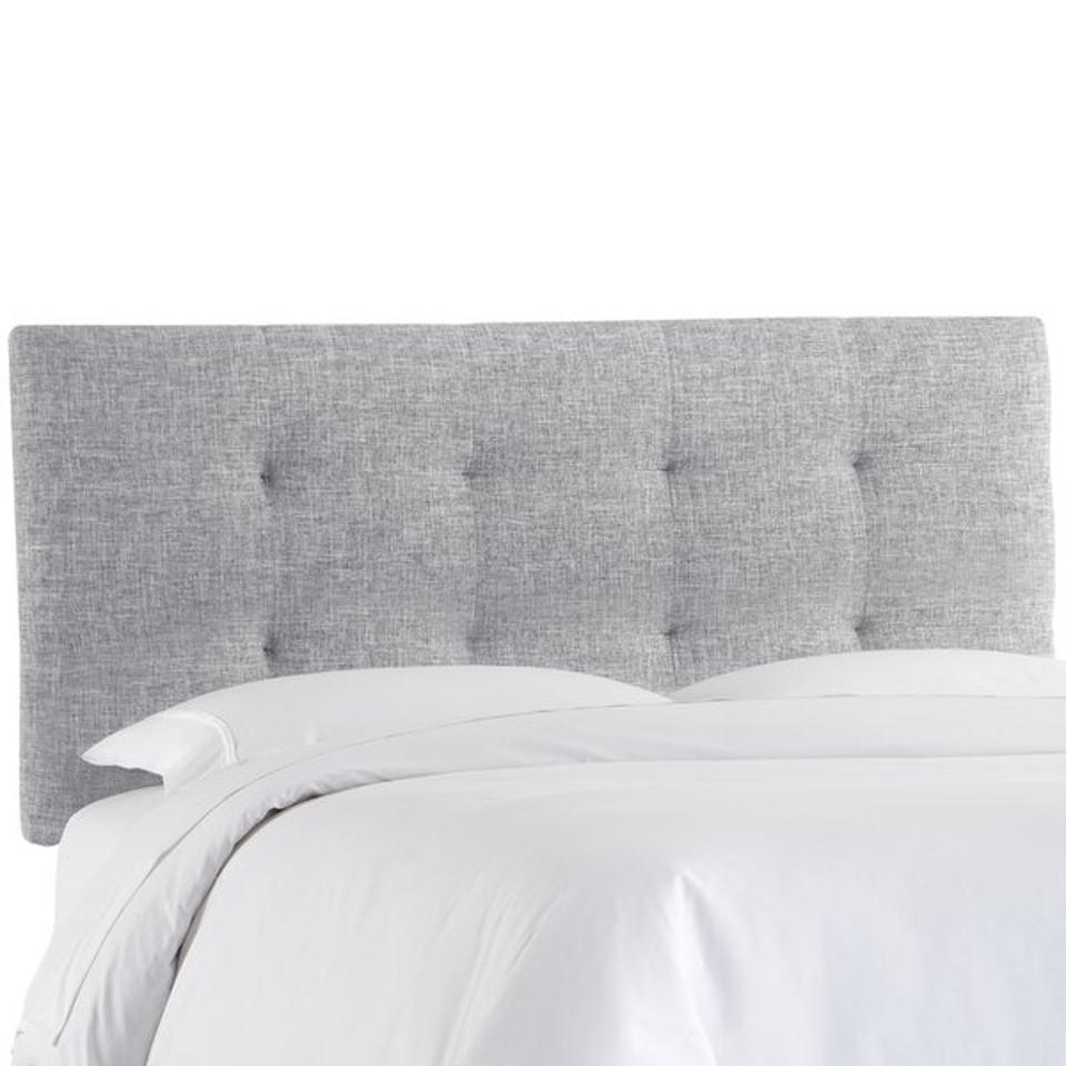 Abram Upholstered Headboard in gray with a bed up against it