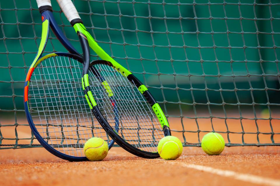 Tennis rackets and balls leaned against the net.