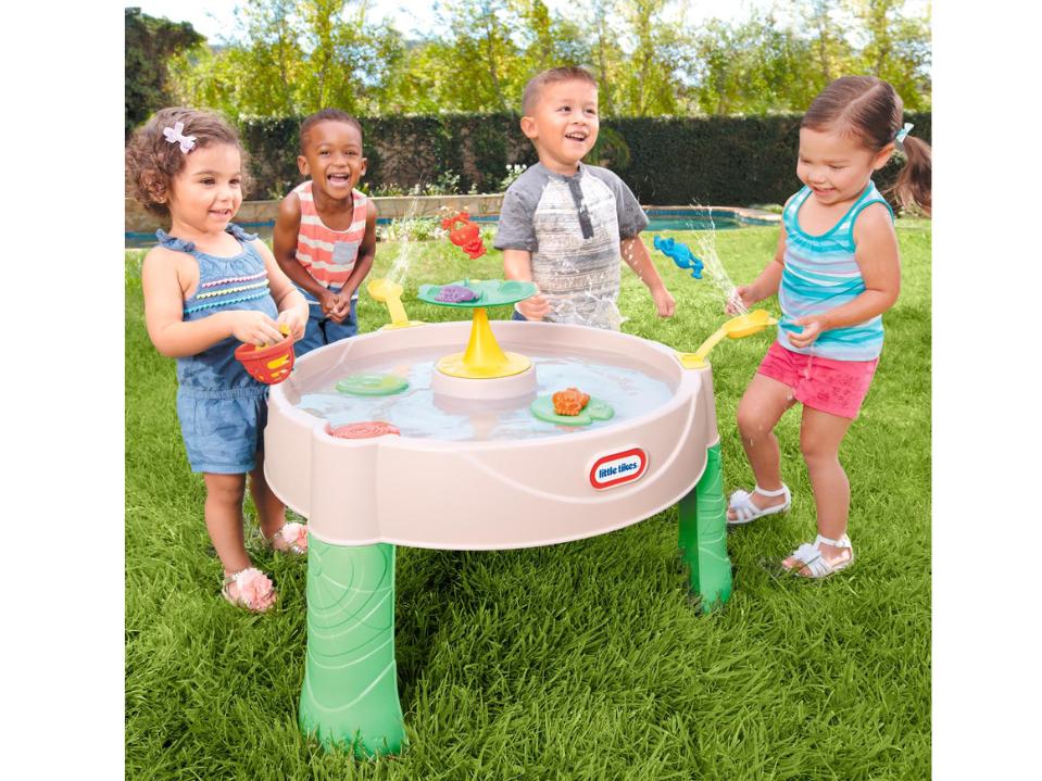 4 toddlers playing around Little Tikes Frog Pond Water Table on grass outside