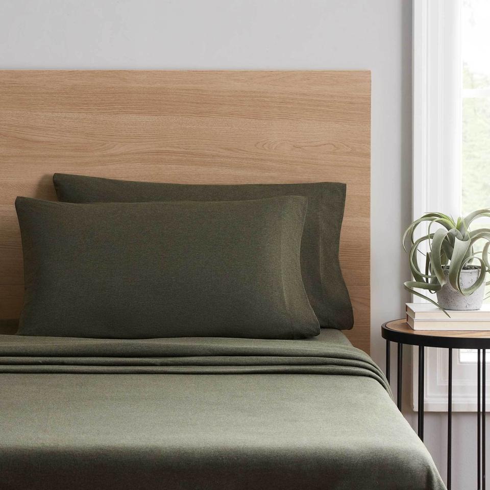 Mainstays Extra Soft Jersey Sheets in green on bed next to bedside table with a plant