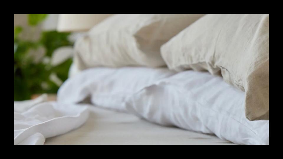 Some pillows on a bed covered with Avocado organic linen pillowcases