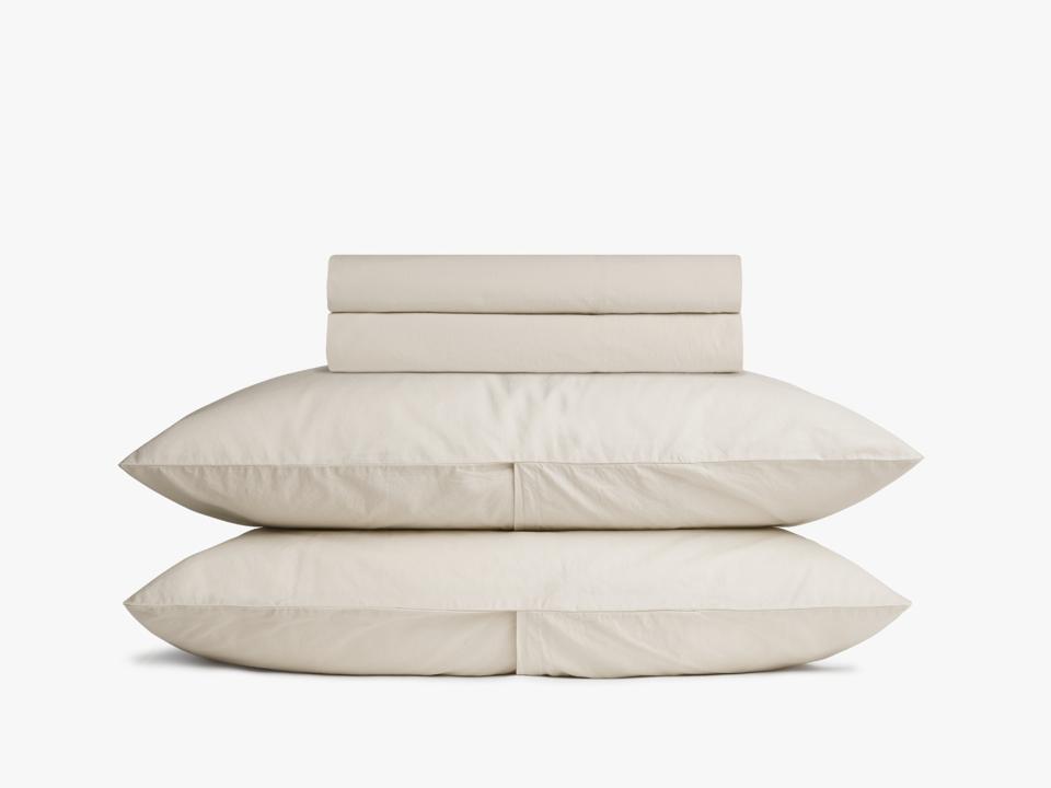 Parachute sheets folded and stacked on two pillows on white background.