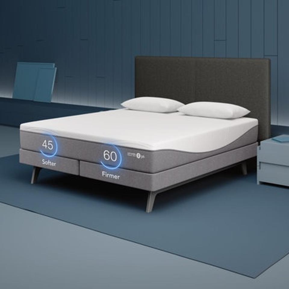 The Sleep Number Adjustable Base and mattress in a room with blue walls and grey flooring. 