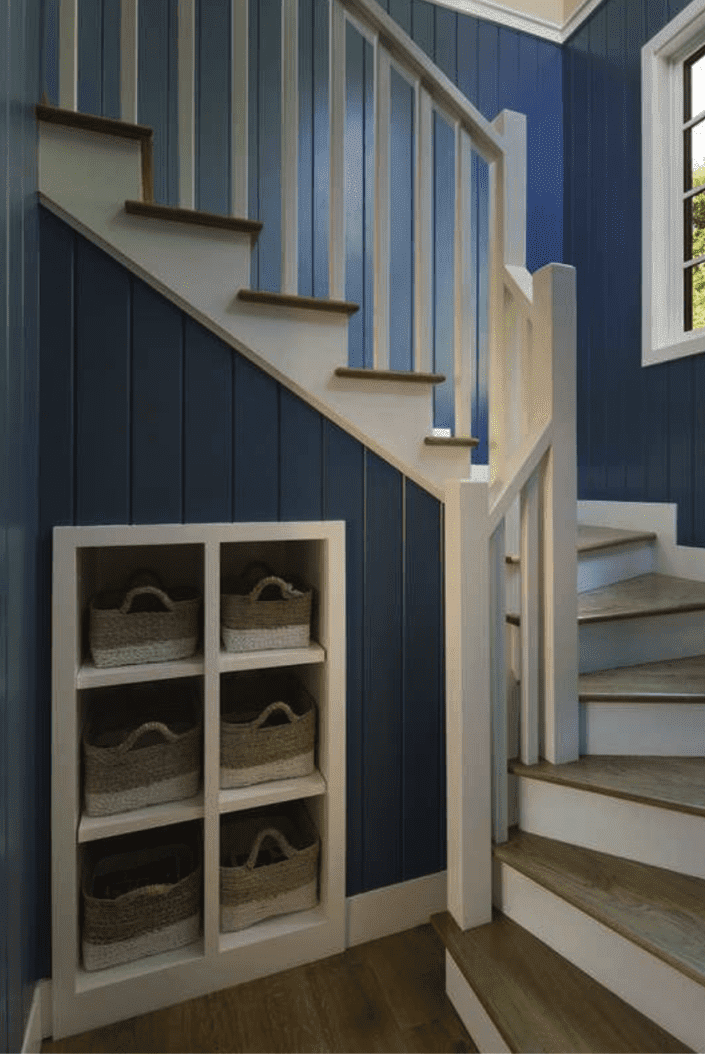 escalier en colimaçon avec des murs bleus et des petits trous dans les murs avec des paniers de rangement