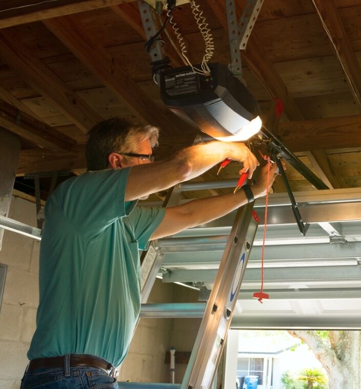 mise en scène de garage - homme réparant la porte de garage