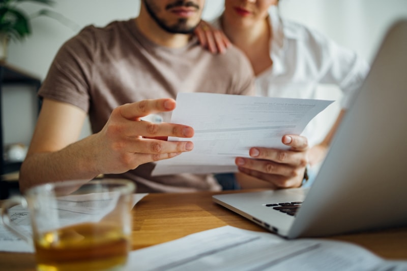 éléments à prendre en compte dans votre bail d'appartement - couple regardant une facture de services publics