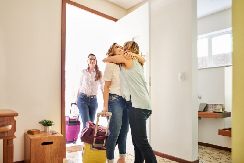 choses à rechercher sur votre bail d'appartement - une femme accueille deux invités à la maison