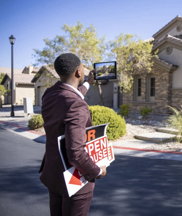 Un agent immobilier afro-américain prépare une maison pour la vente.